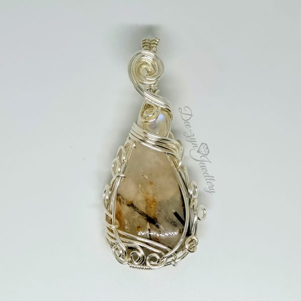 Rutilated Quartz and Rainbow Moonstone Captured in a Silver Filled Wire Sculptured Pendant on white background. Close up